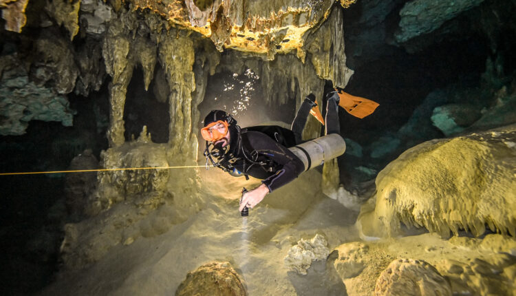 Scuba diver in sidemount configuration in a submerged cavern